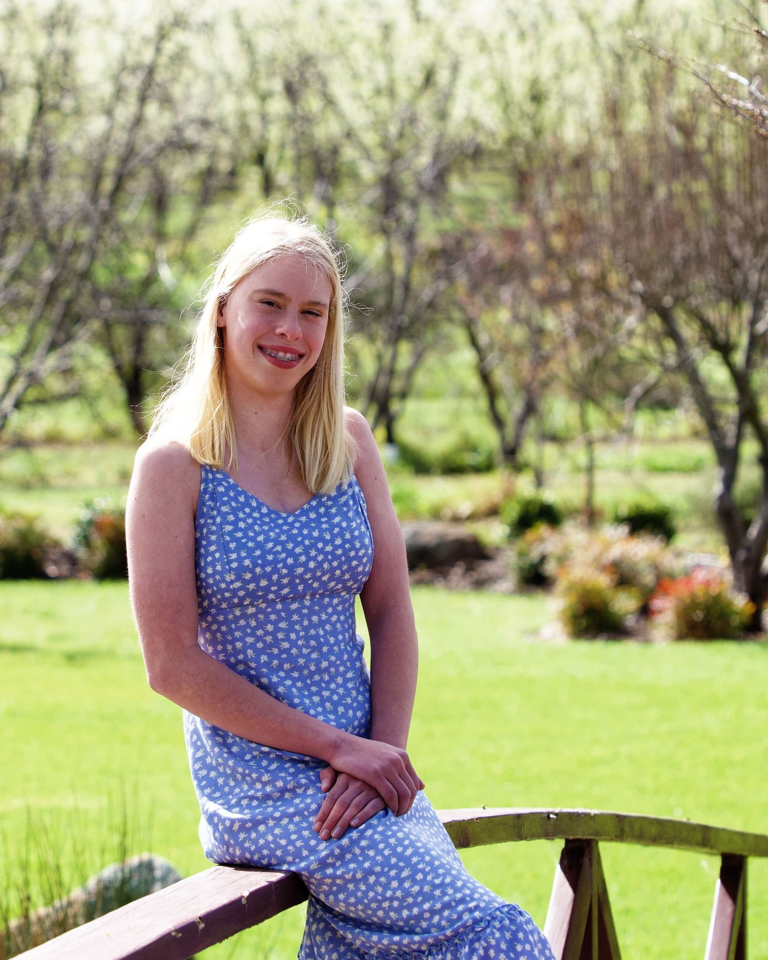 spring portrait of female youth wearing blue and white floral sun dress on the grounds of the core cider house perth wa