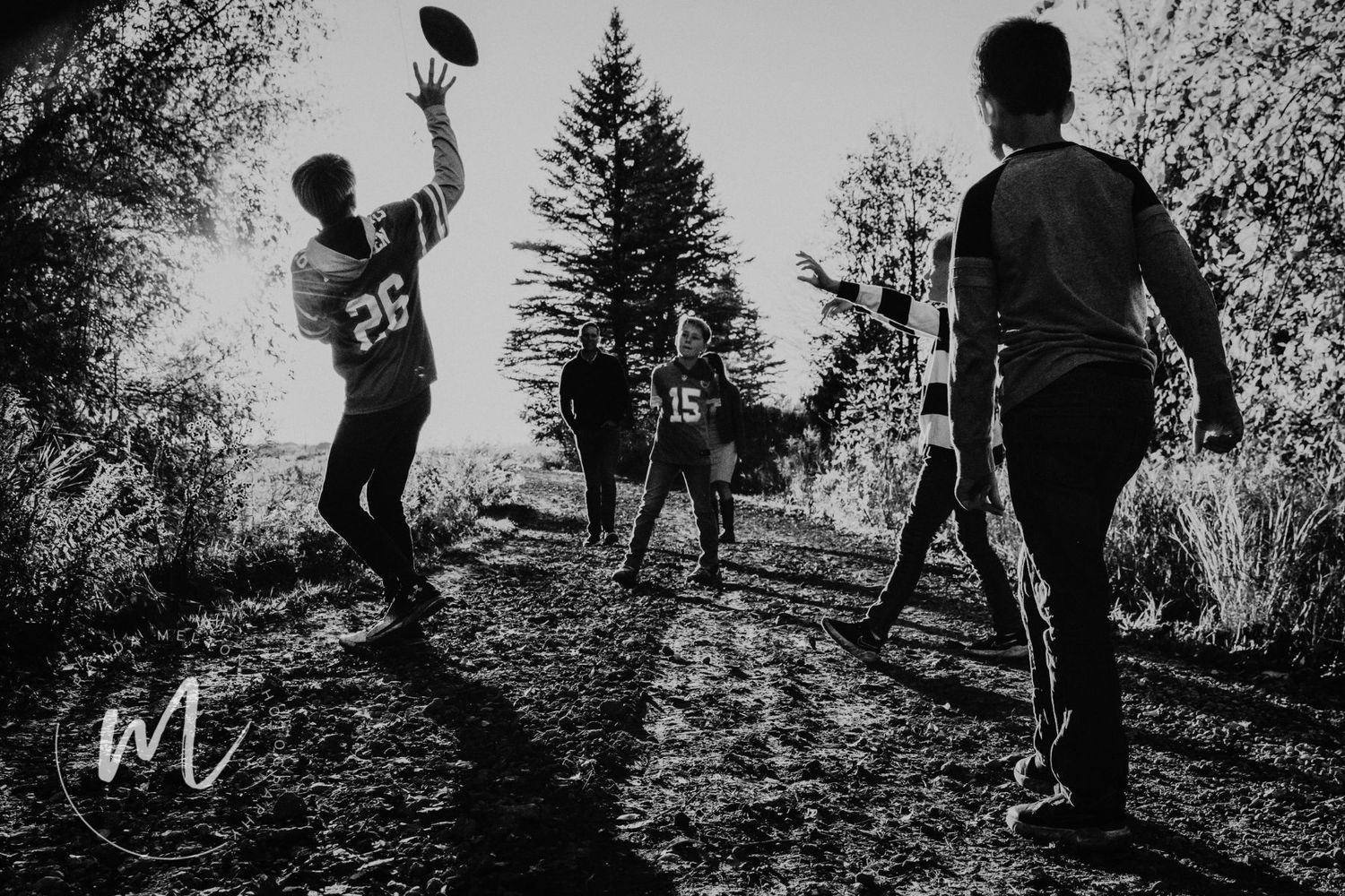 A family and their dogs playing football at their country home shows as a concept for family photo ideas in the Twin Cities
