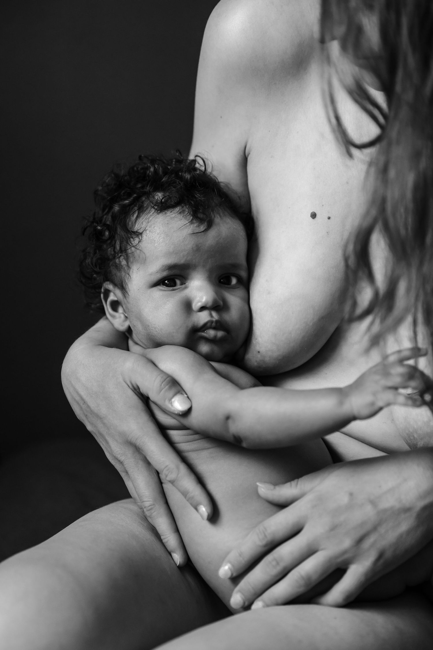 baby stares directly at camera in fine art lifestyle portrait by newborn photographer london