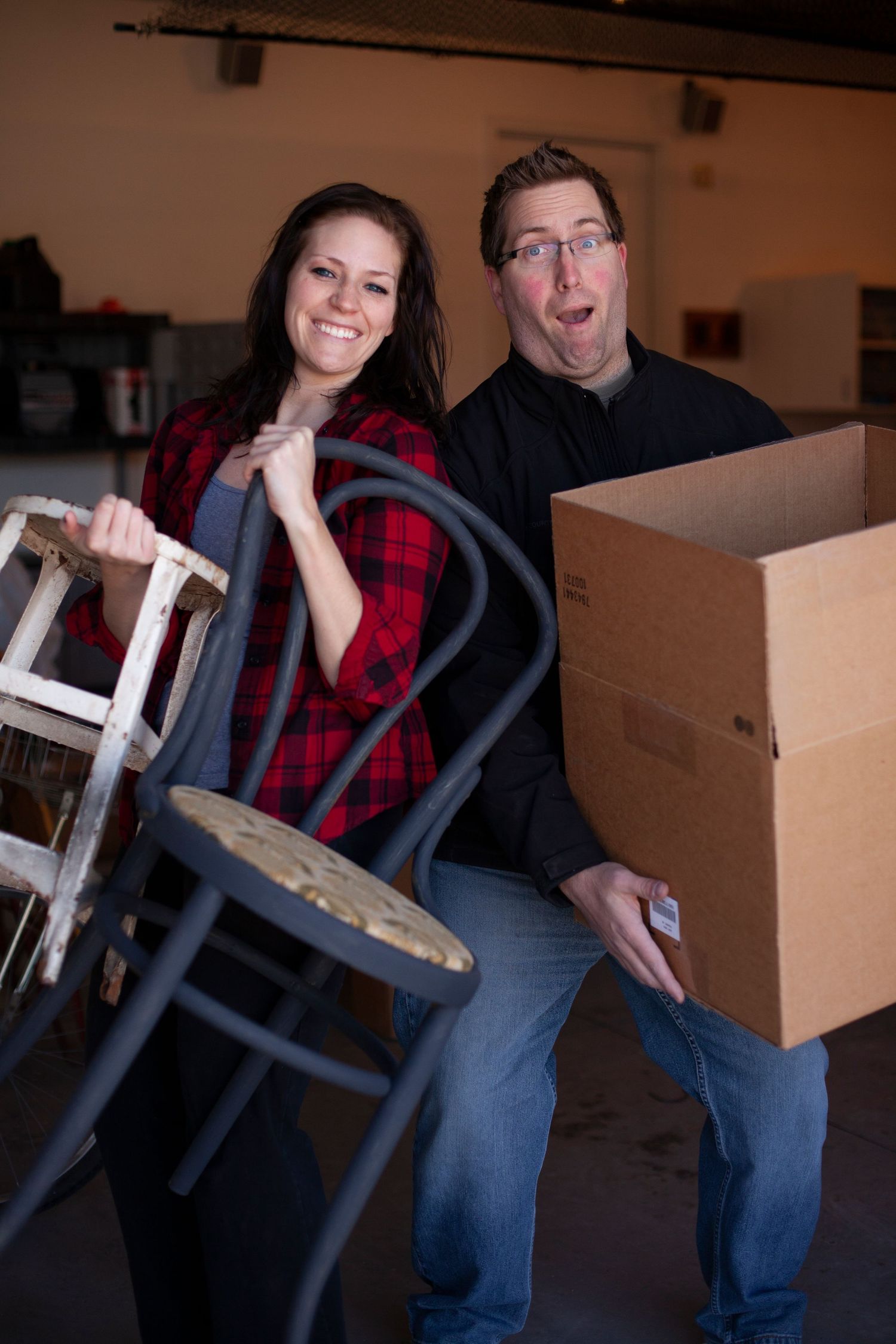 People in matching plaid shirts moving boxes and furniture.