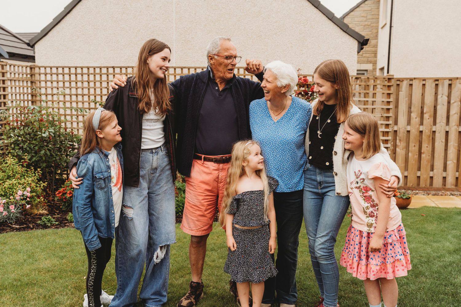 Multi-generational group posing together in a backyard garden.