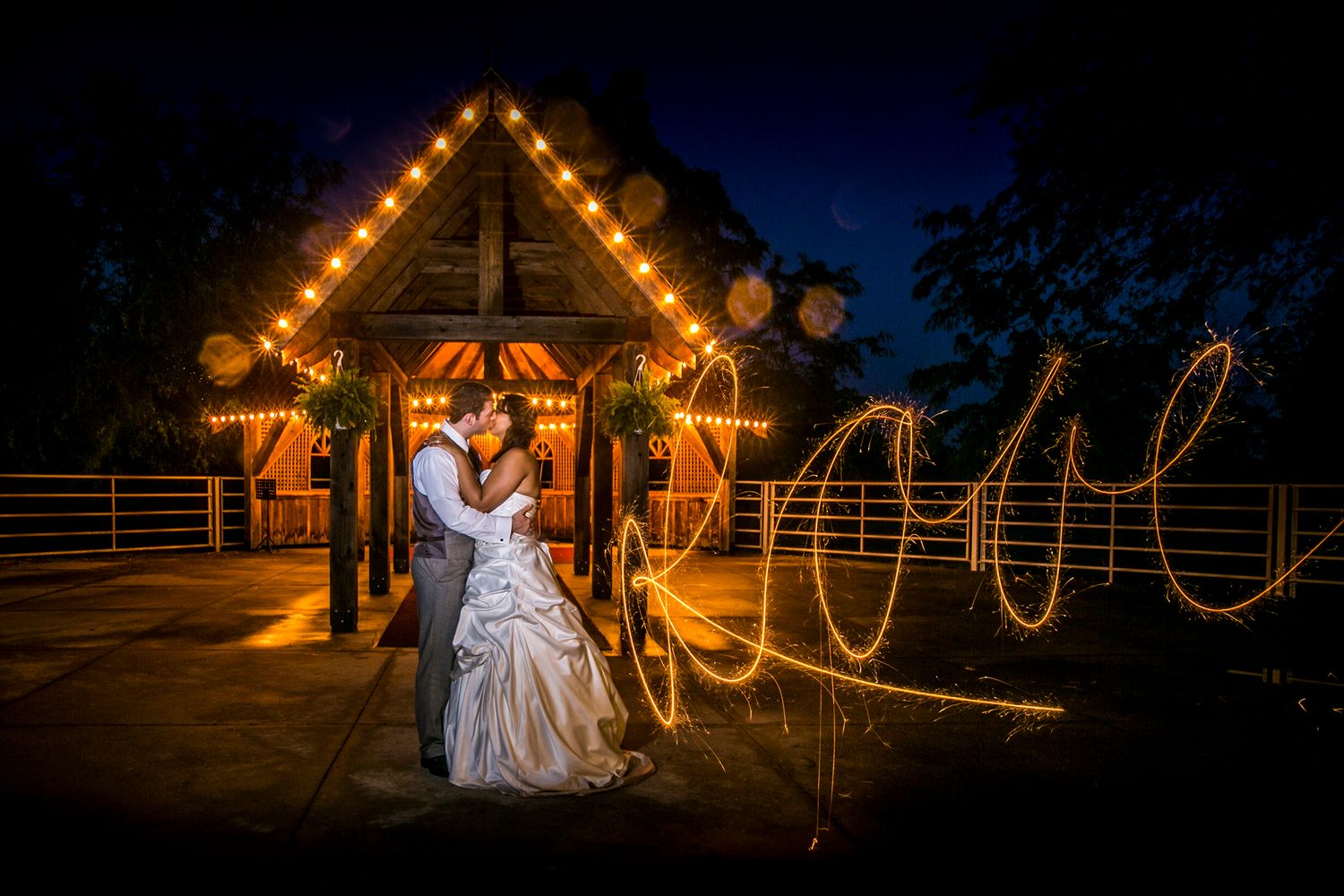 Nighttime wedding photos with illuminated barn and light painting effects.