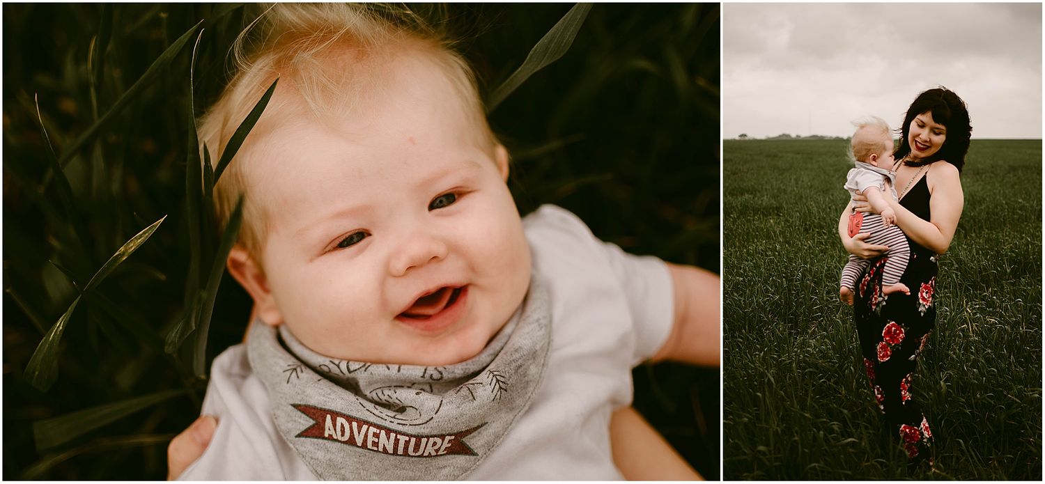 Smiling baby in gray shirt next to parent in floral dress against green field backdrop.