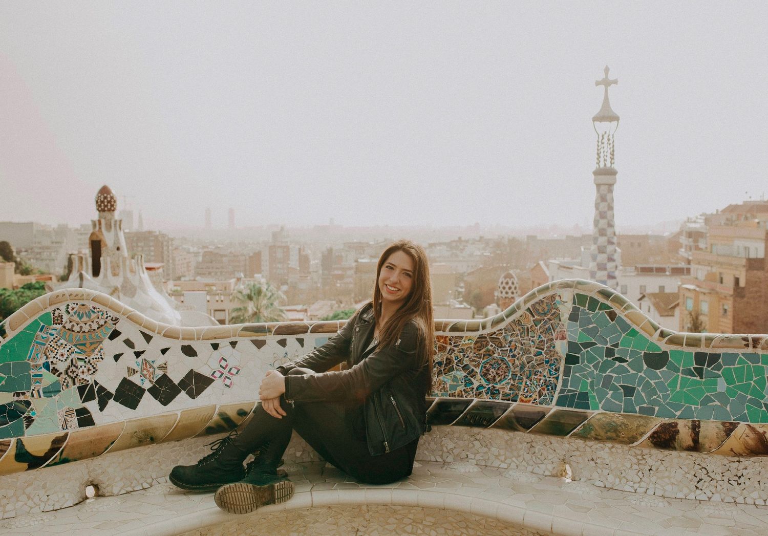 Person lounging on mosaic-tiled wall with ornate architectural details in Mediterranean setting.