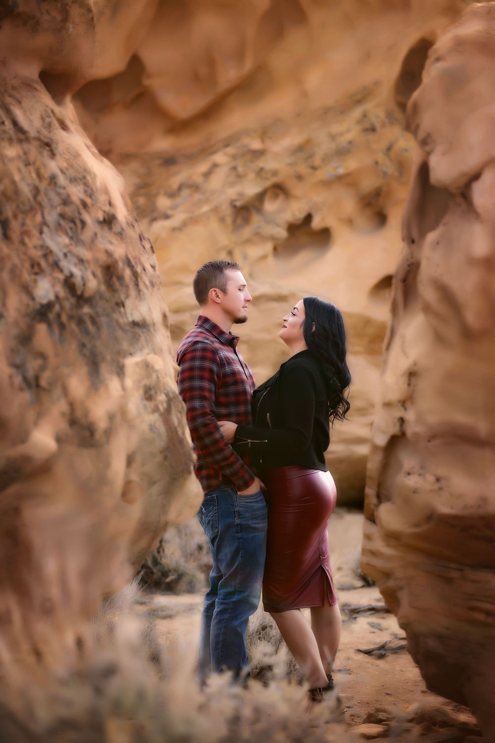 A couple shares an intimate moment among red rock canyon formations.