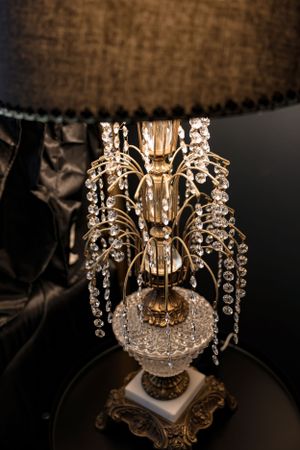 Ornate crystal table lamp with cascading glass beads and decorative metallic base.