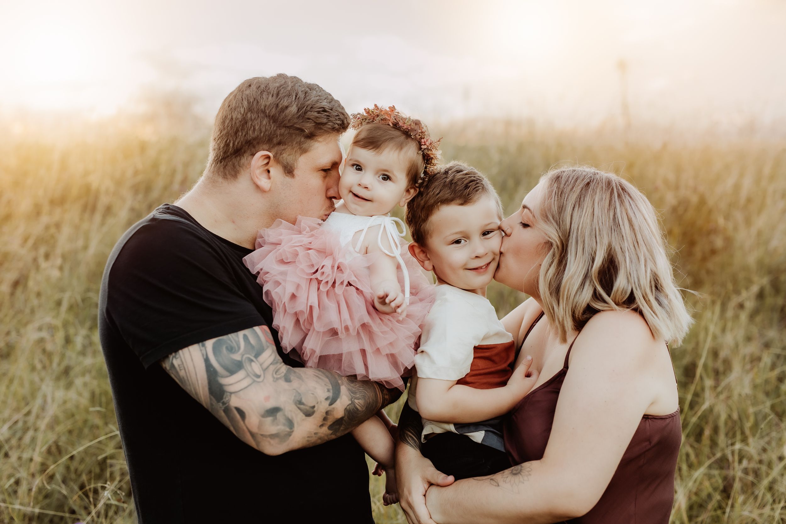 Sweet family interactions and cuddles in an outdoor setting at sunset.