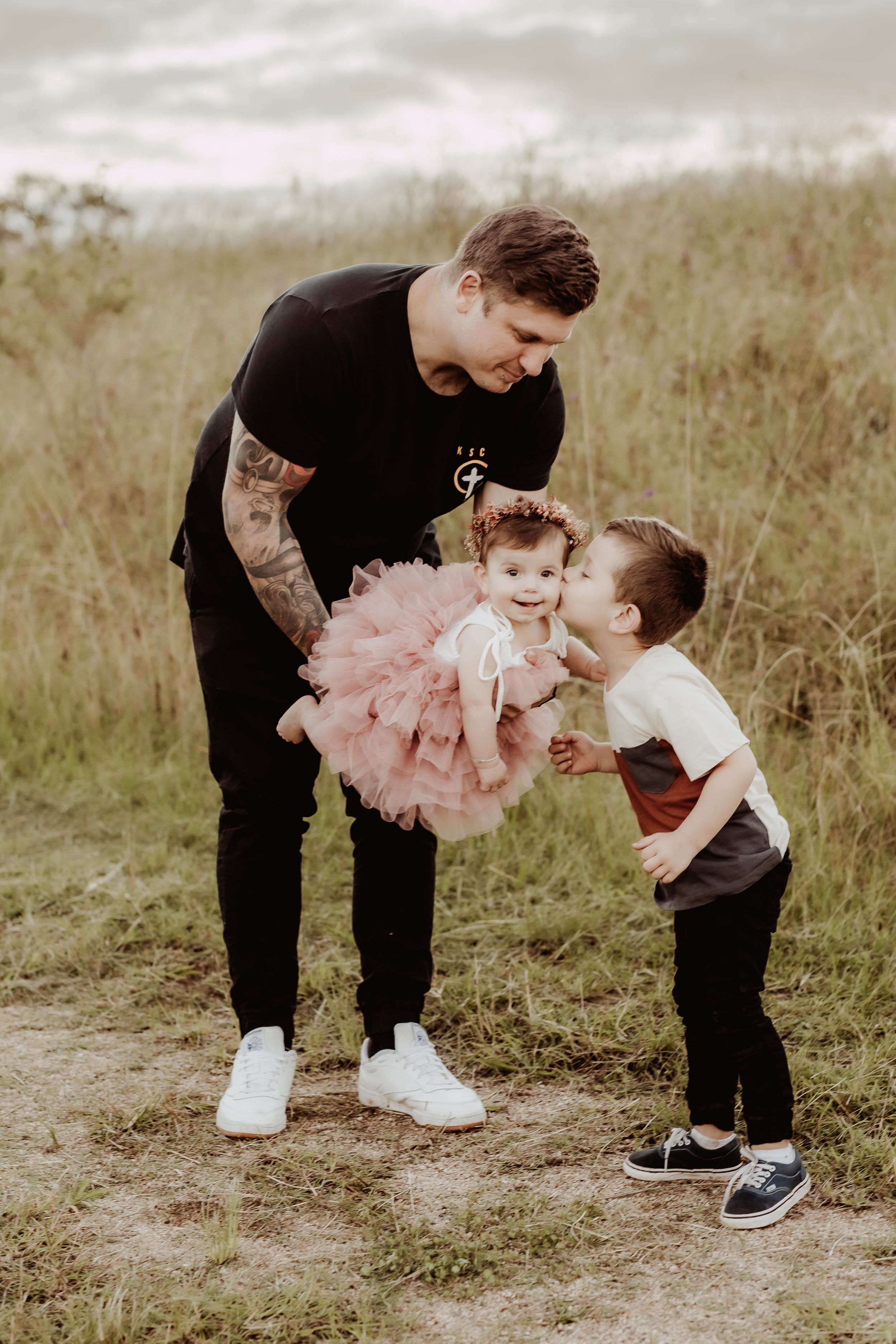 Playful family moments captured in a rustic field setting.