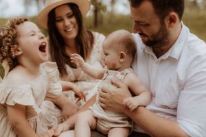 Family shares joyful moments together during outdoor portrait session in natural setting.