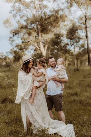 Family shares intimate moments in golden field during sunset portrait session.