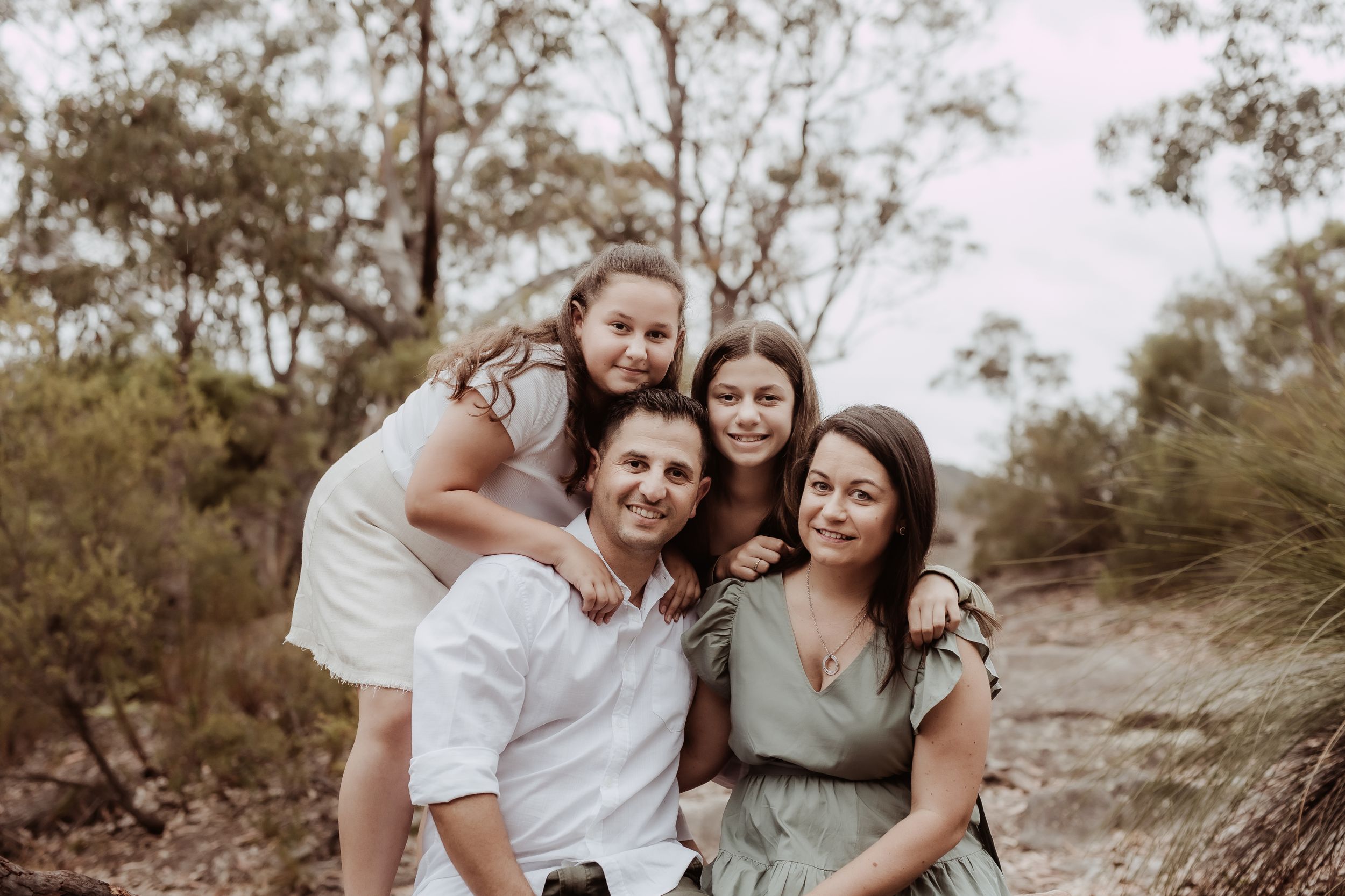 Family portrait session in natural outdoor setting with eucalyptus trees.