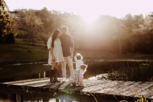 Golden sunset silhouettes of a family walking together in a scenic outdoor setting.