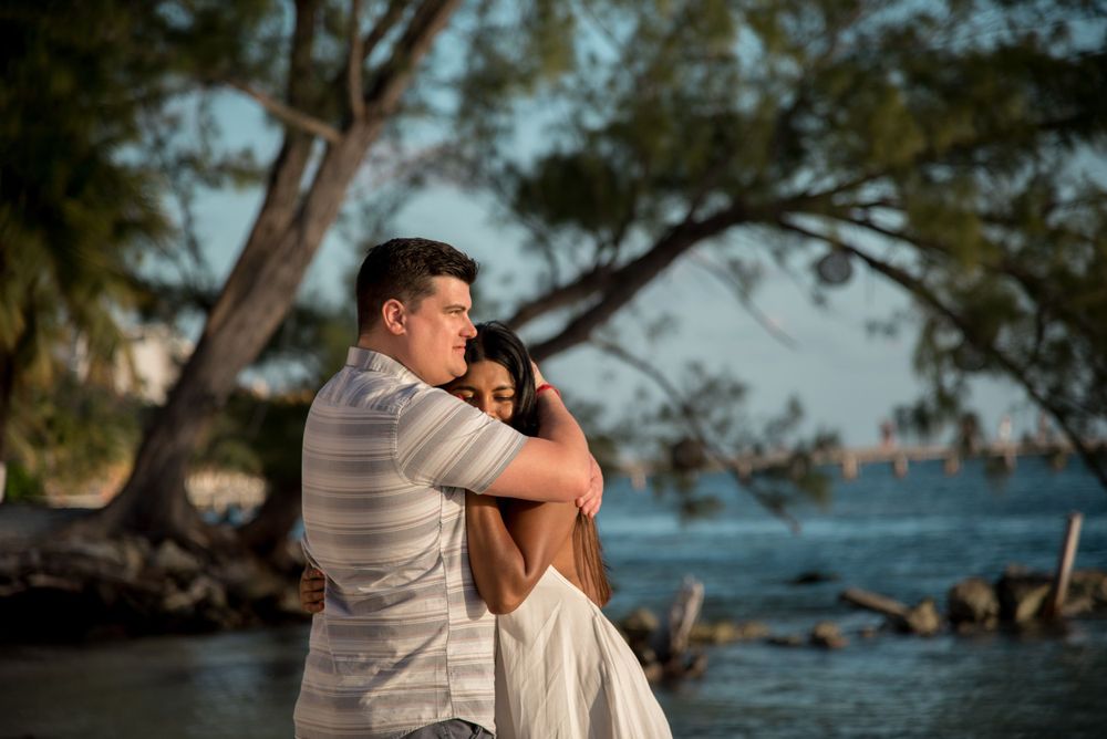 Maureen and John embracing each other tenderly while standing on the sandy beach