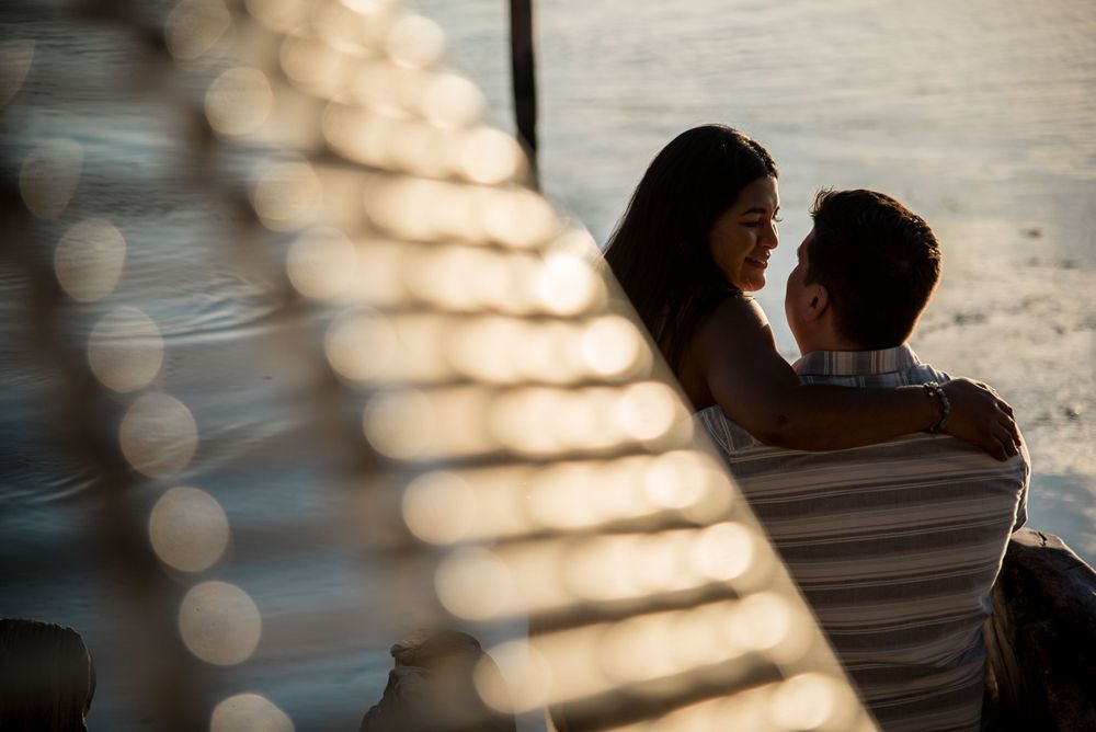 The couple sitting on the beach, sharing an intimate moment during sunset