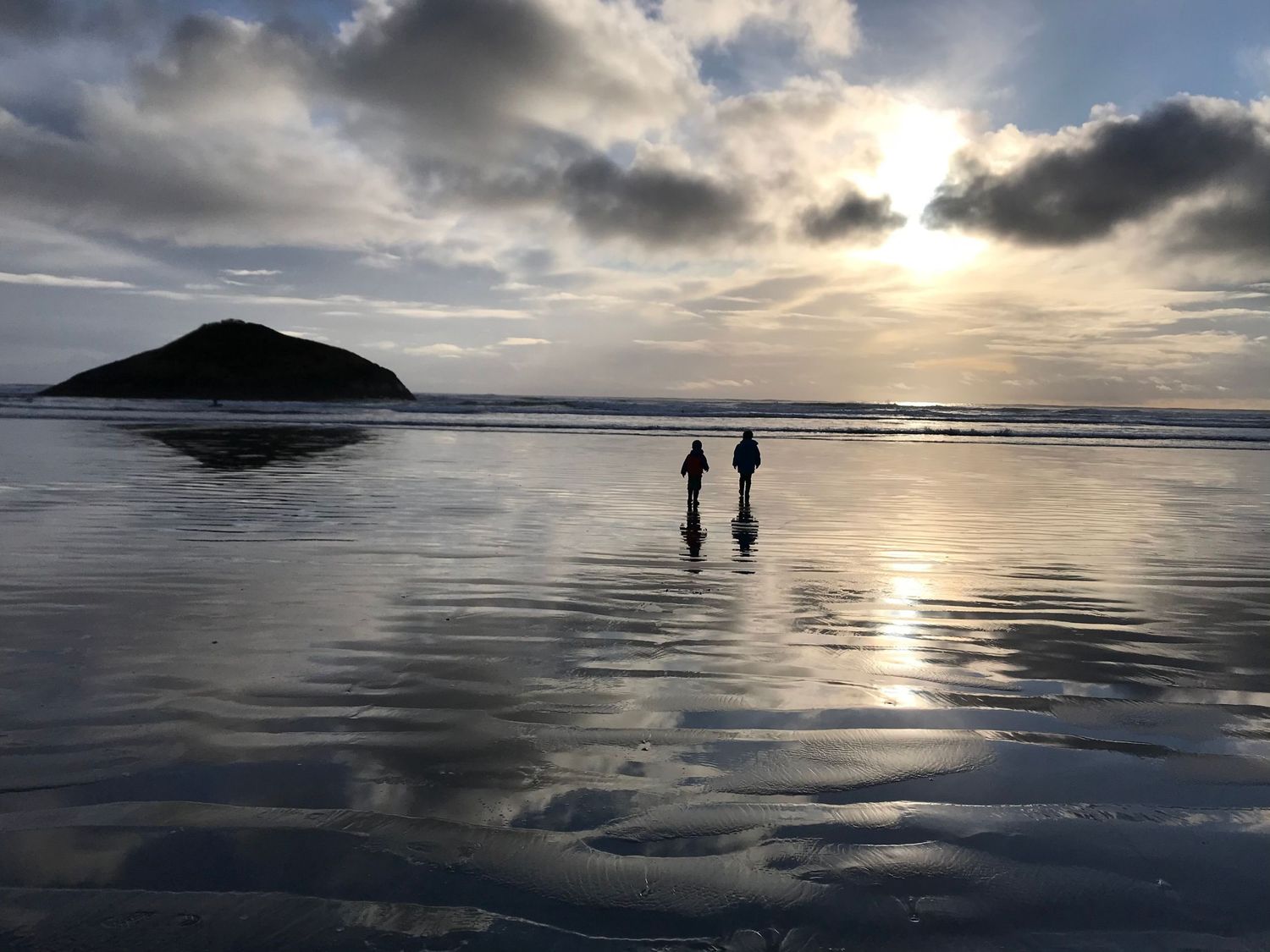 Silhouette of two boys at golden hour at the beach.