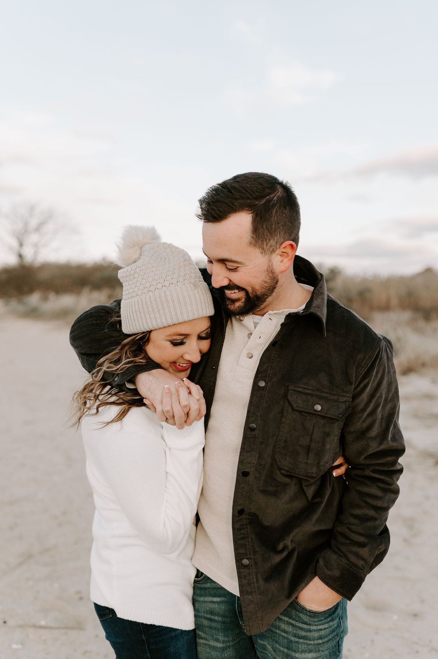 Couple laughing and embracing outdoors on a winter day.