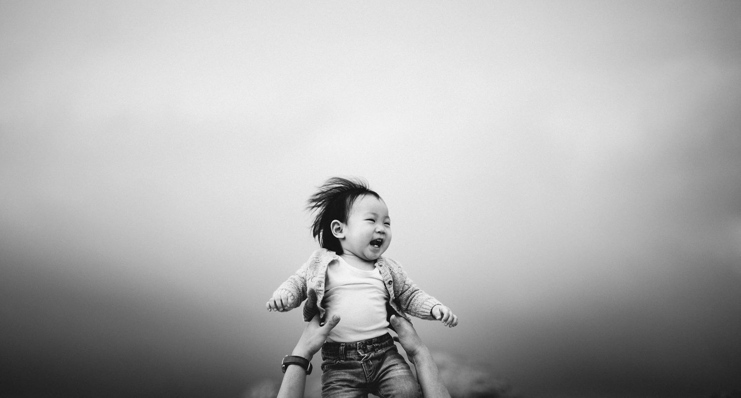 happy kid being held up high on the sky.