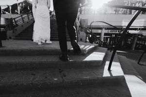 Black and white photo showing formal shoes walking across steps at an event.