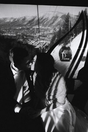 Couple enjoying scenic mountain views from inside a gondola lift car.