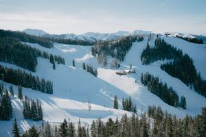 Panoramic view of snow-covered ski slopes and trails in a mountain resort.
