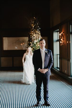 Elegant wedding portrait with couple standing in front of decorative holiday decor.
