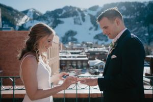 Wedding ceremony on a mountain-view terrace with bride reading vows.