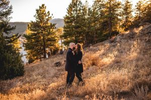 Couple kissing on a sunlit hill side for engagement photos