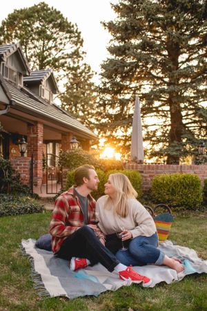 Couple sitting on a blanket looking at eachother  during sunset for photos