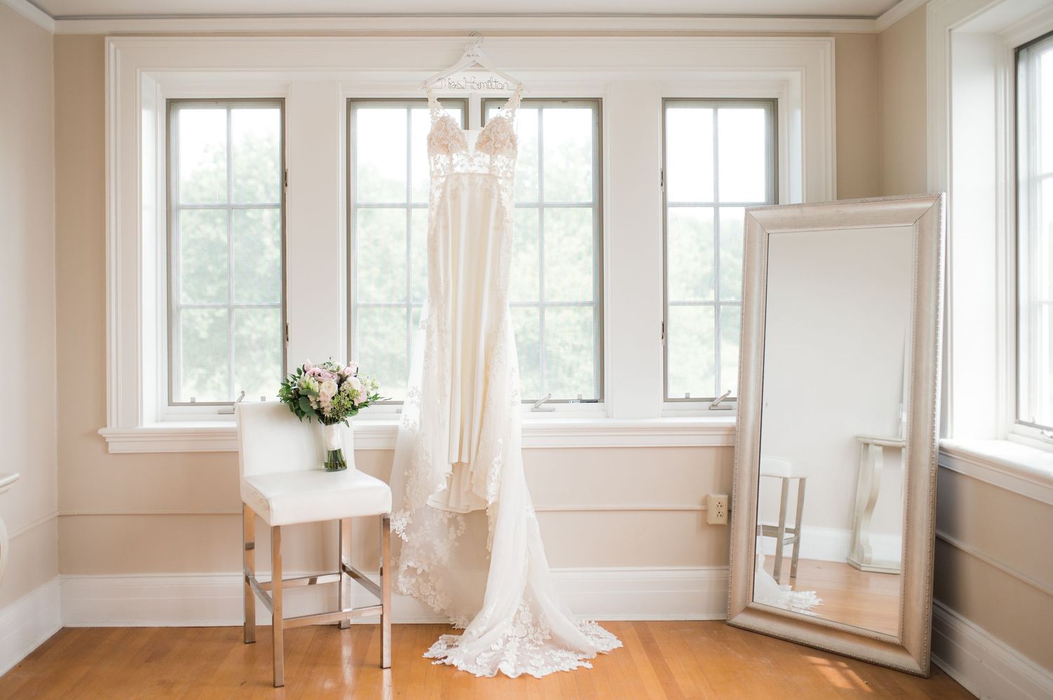 Bright, minimalist white room with large windows and hardwood floors perfect for wedding photography.