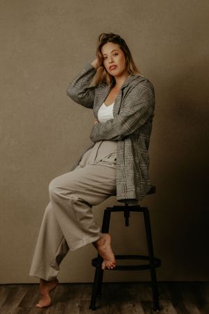 Lorny posing on a stool in business casual