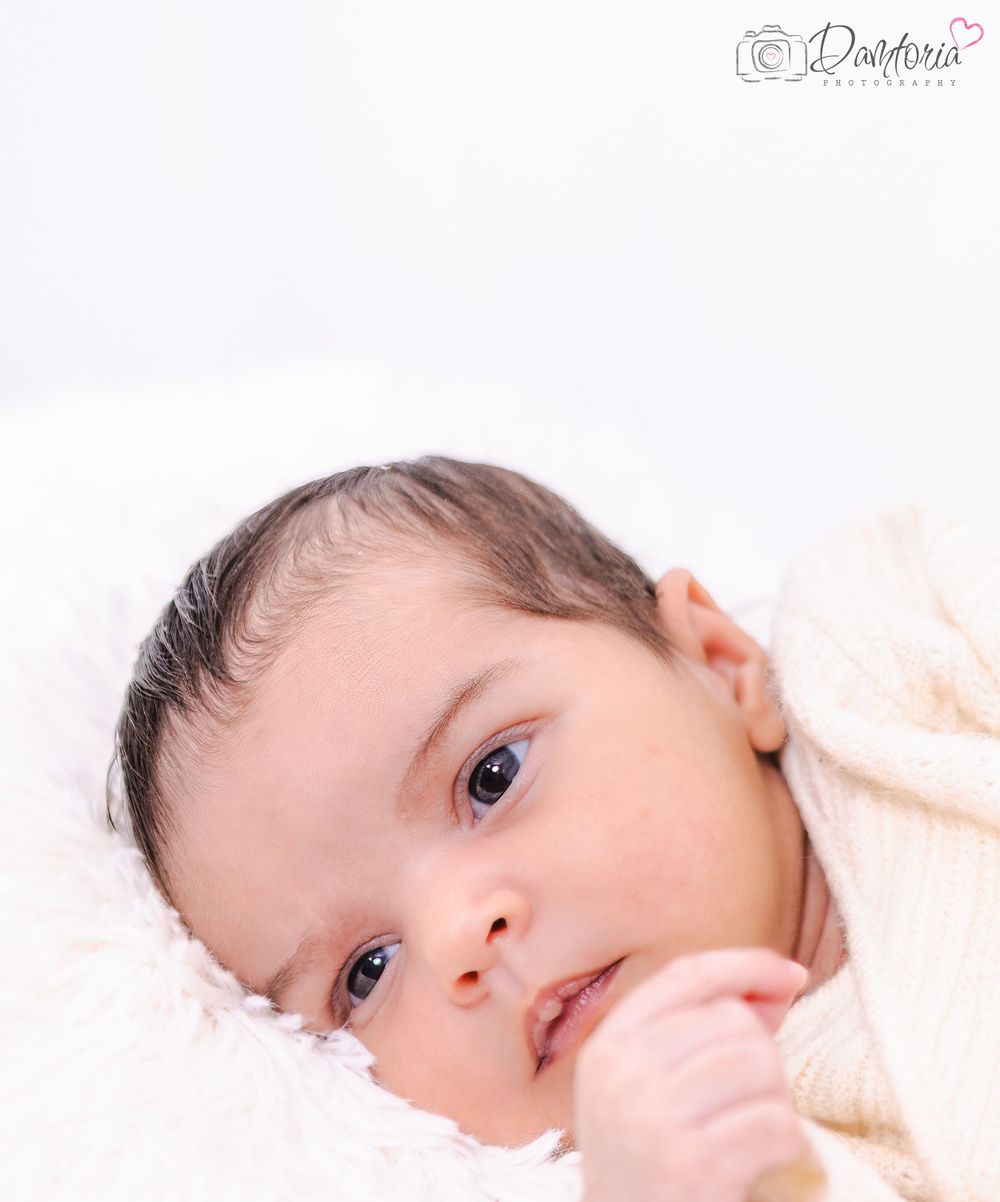 Sweet newborn baby photography series against soft white backgrounds with delicate lighting.