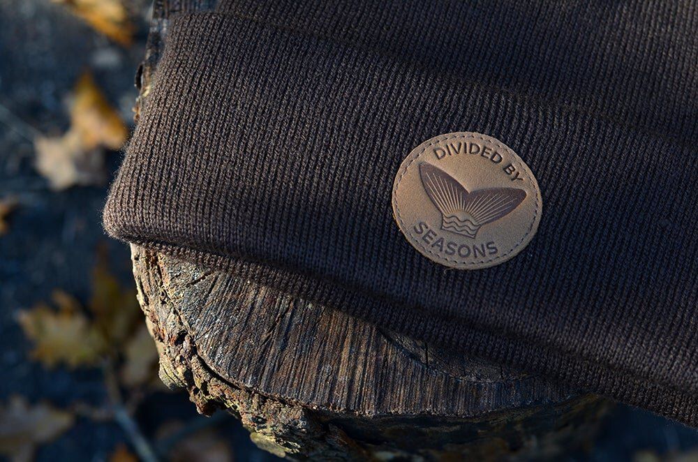 Close-up detail shots of black knit beanie with leather emblem patch.