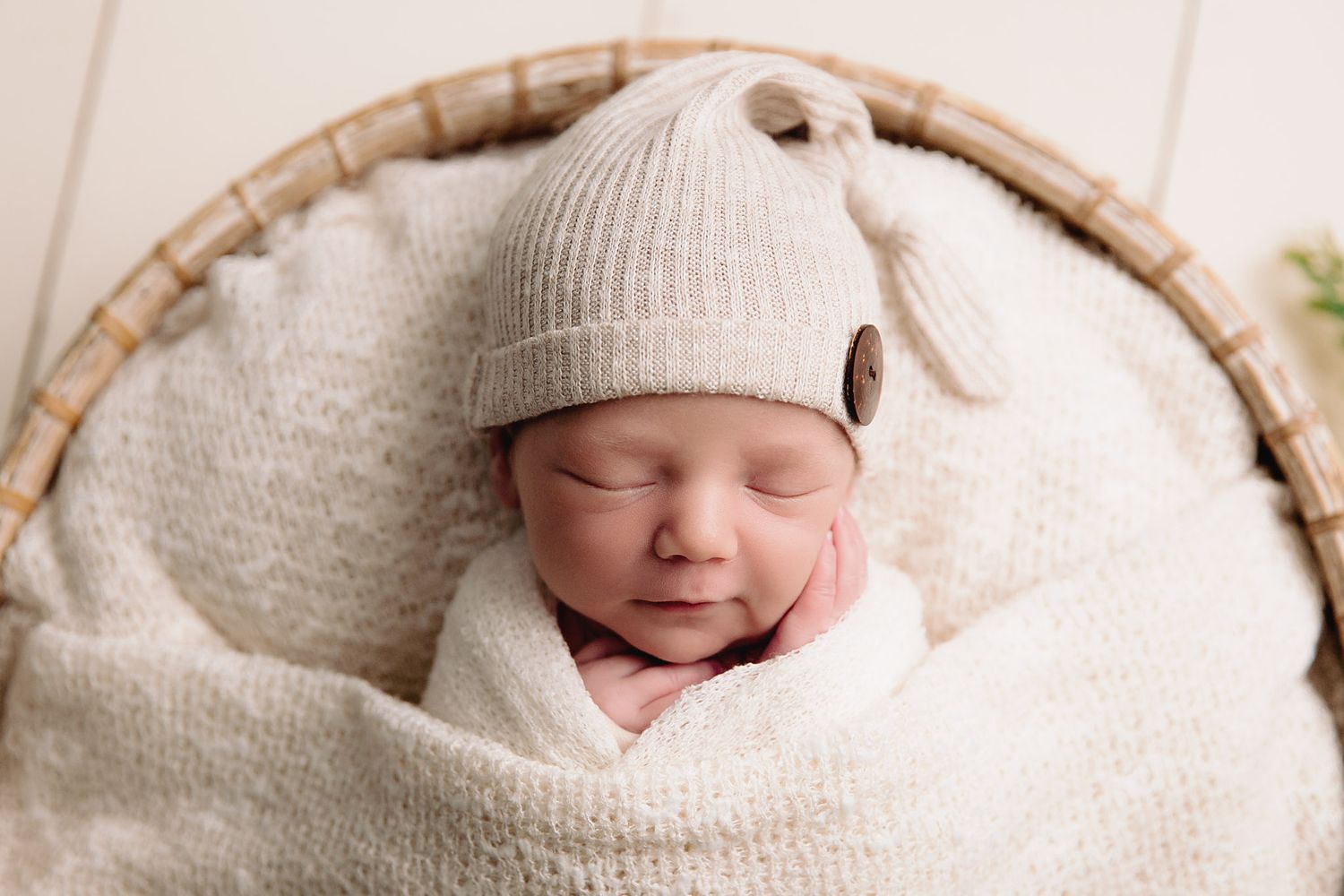close up newborn baby boy sleeping tucked into blanket