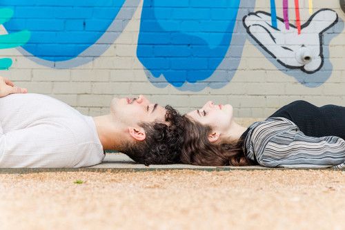 couple laying by graffiti wall