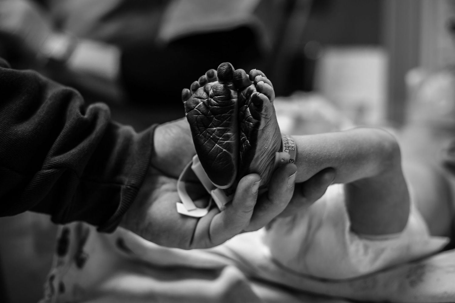 Dad holding his son's feet just after the nurse had put the ink on the to foot print him just after birth in Sioux City.
