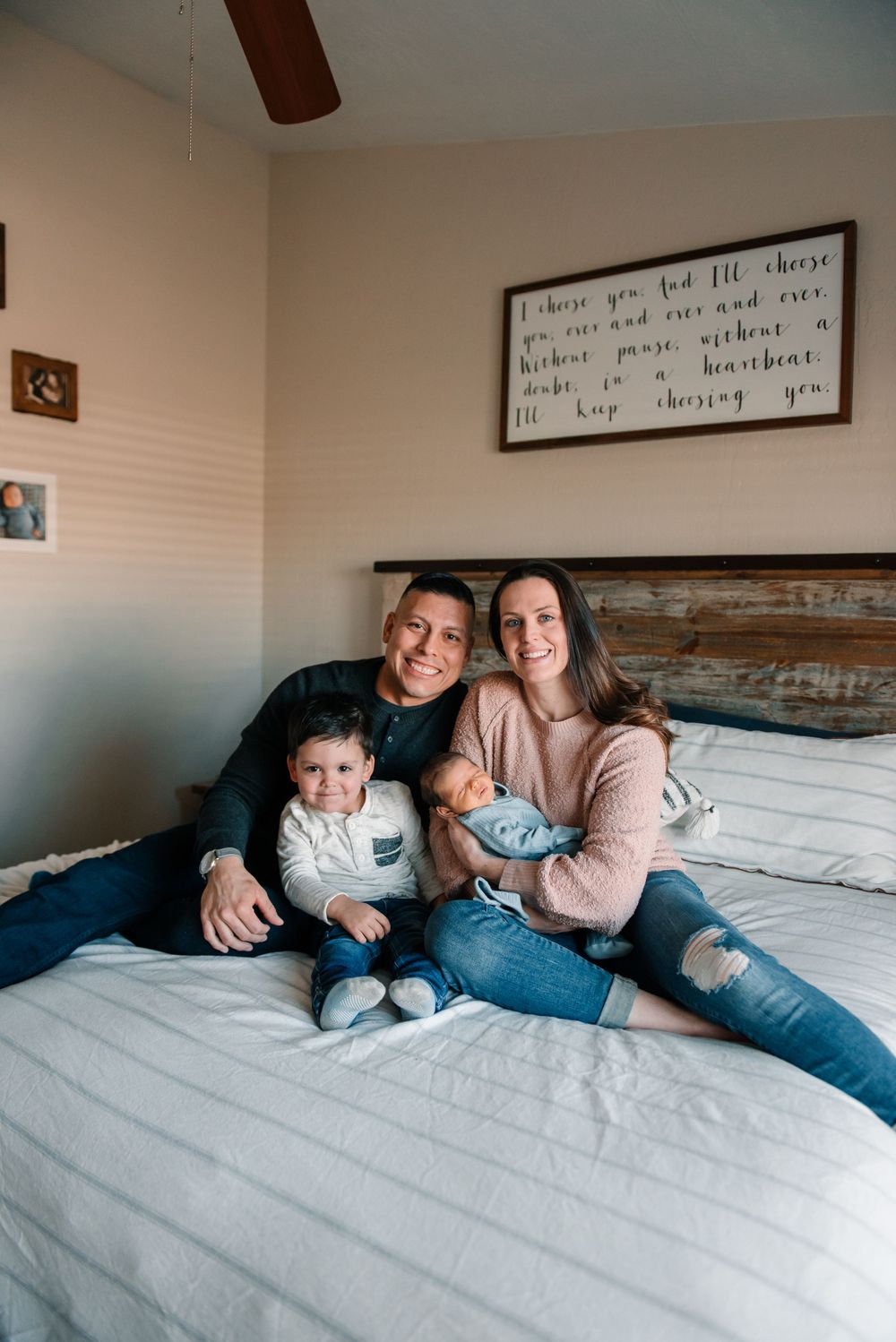 Family sharing tender moments together on a cozy bed with rustic headboard.