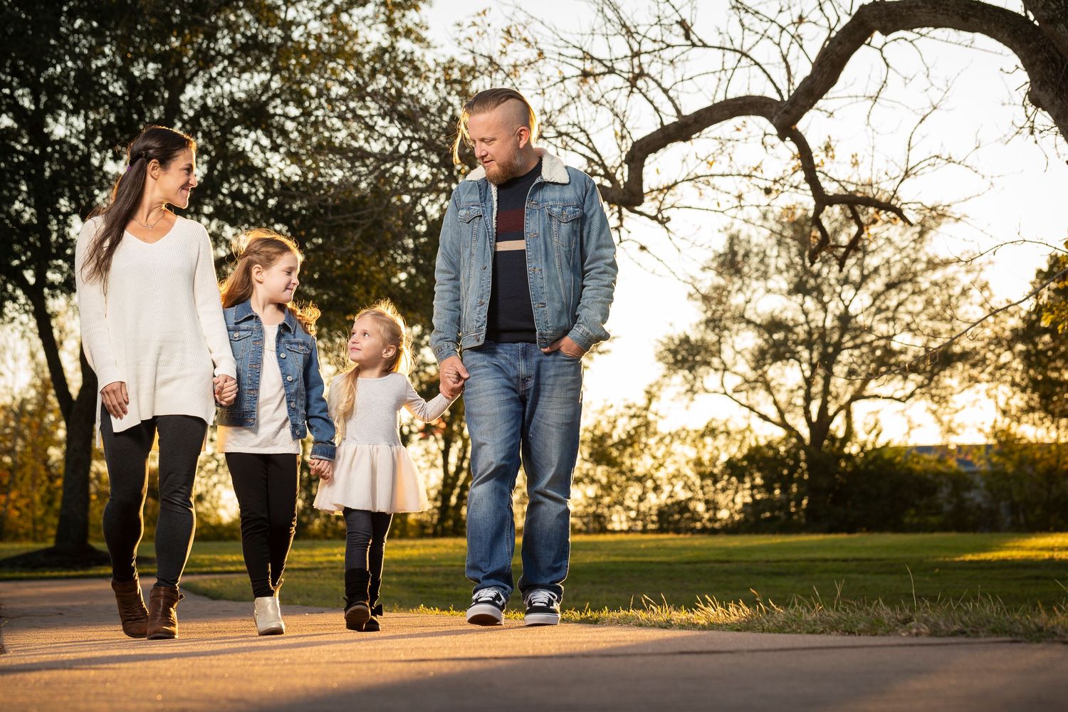 Family walking together on path during golden hour sunset.