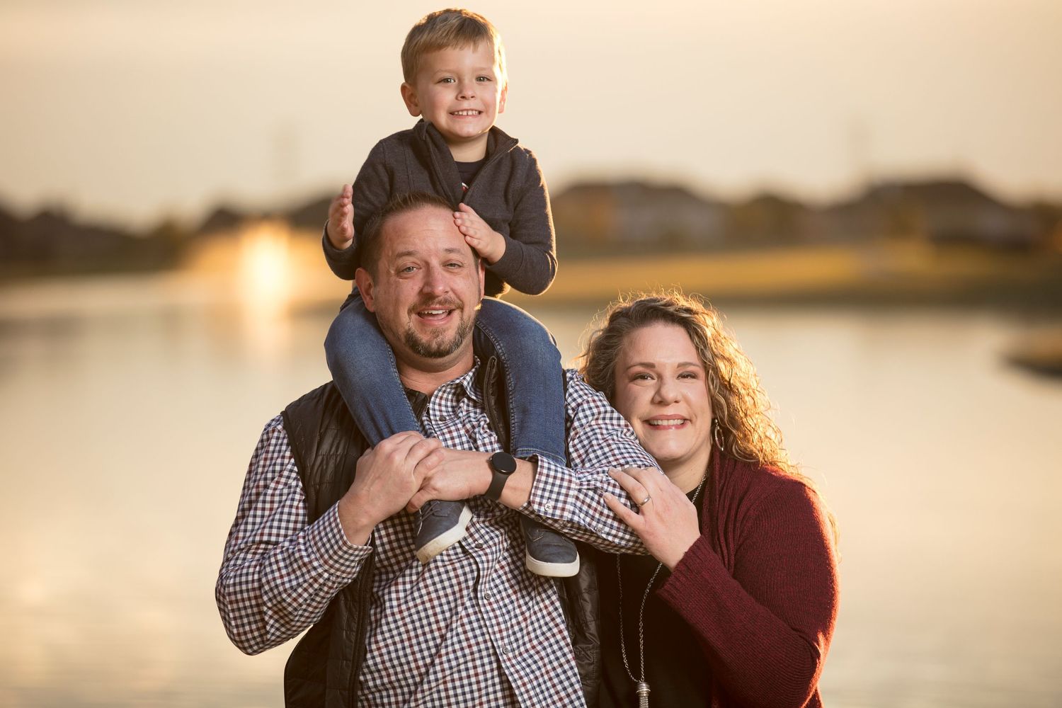 Family portrait captured during golden hour at a waterfront location.