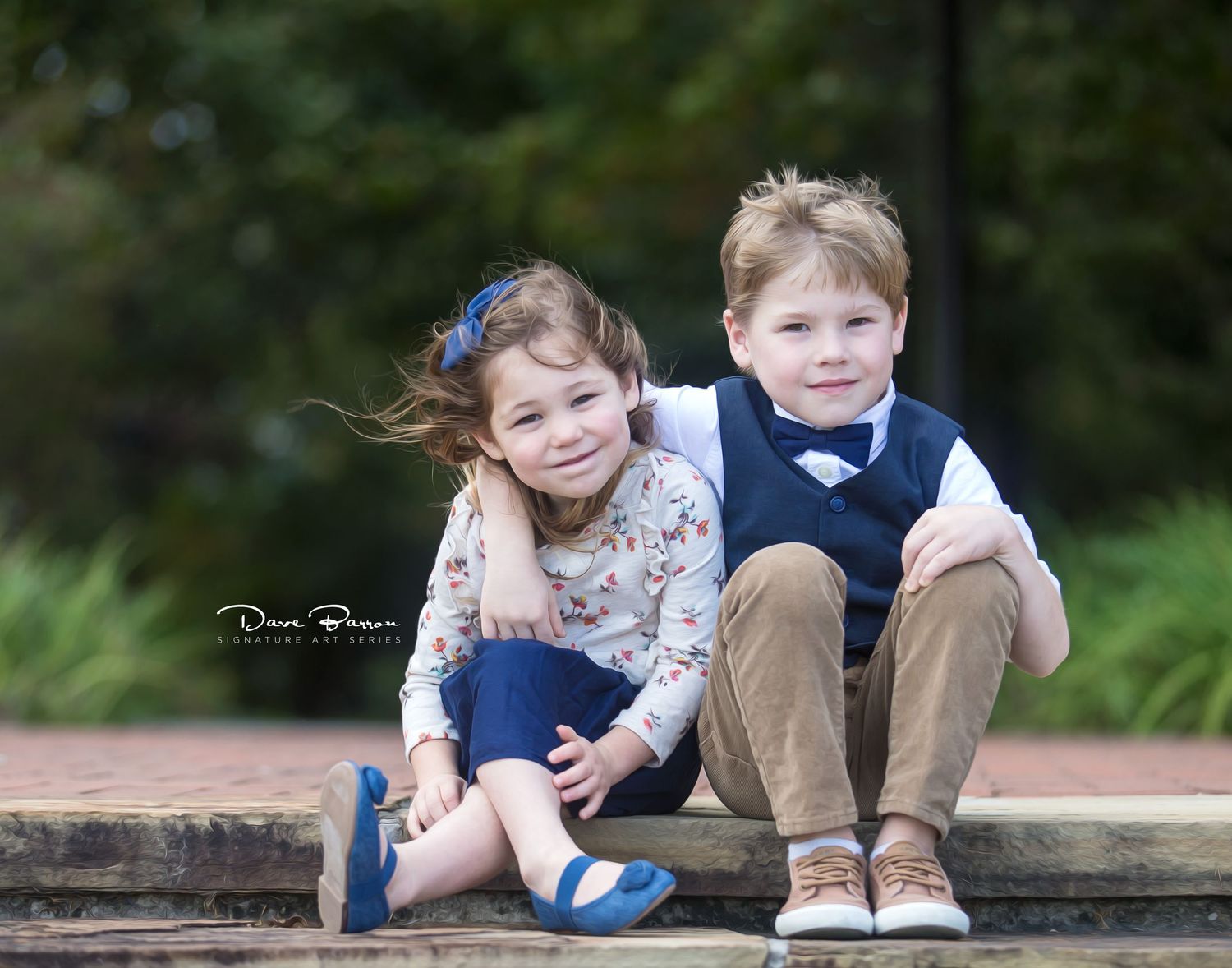 Children sitting together on a wooden bench for a casual outdoor photo.