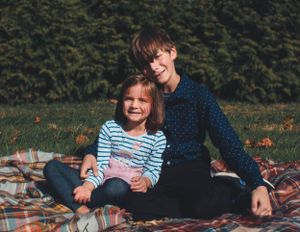 Two people sharing a cozy moment on a picnic blanket outdoors.