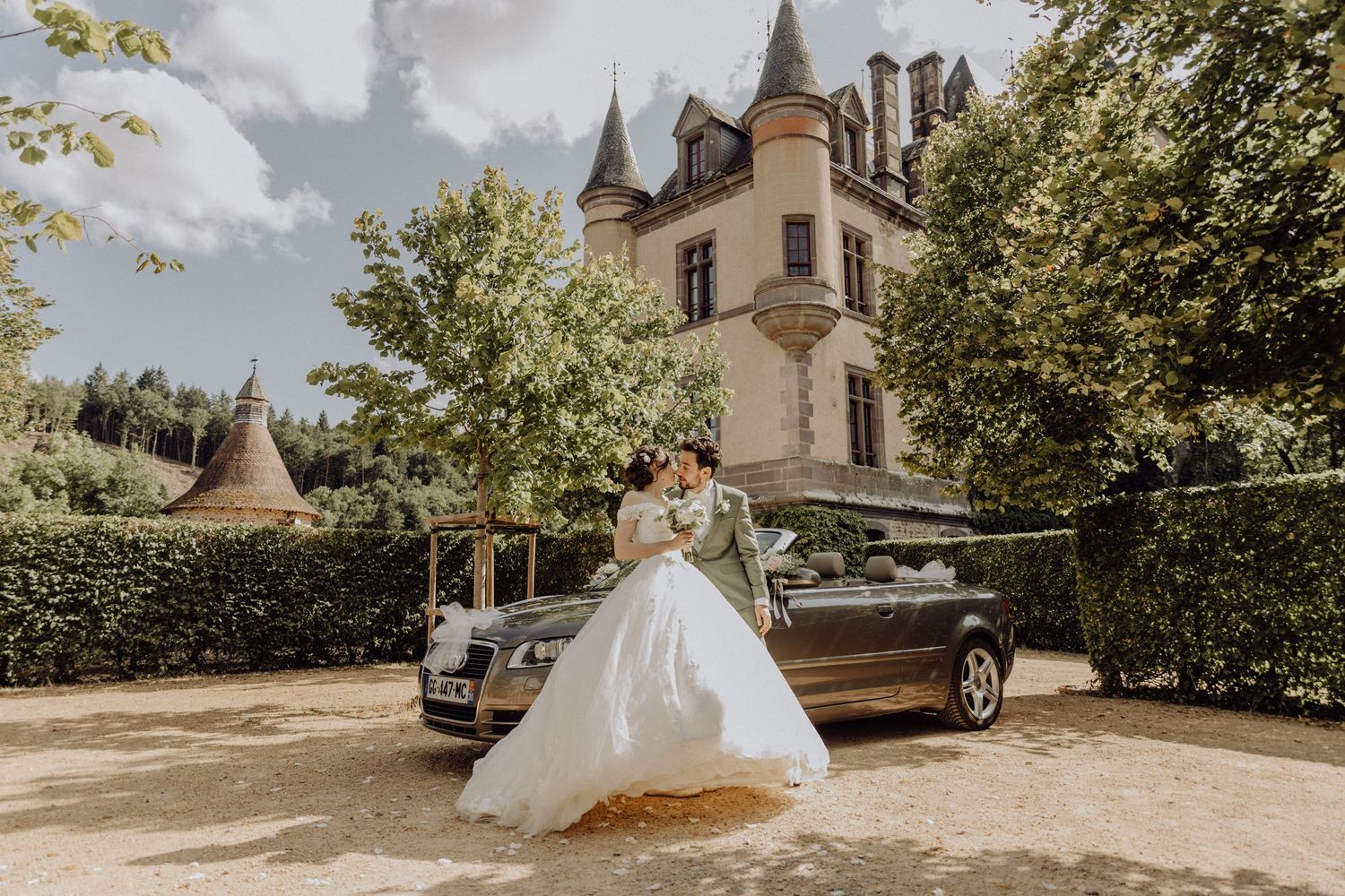 Photographe mariage Auvergne Rhône-Alpes – vue du Château de Miremont, église en pierre et tours entourés de verdure.