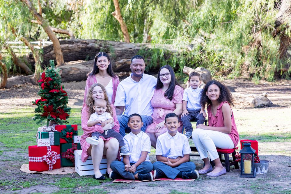 Orange County photographer captures family with seven children posing with Christmas decorations in an outdoor park.