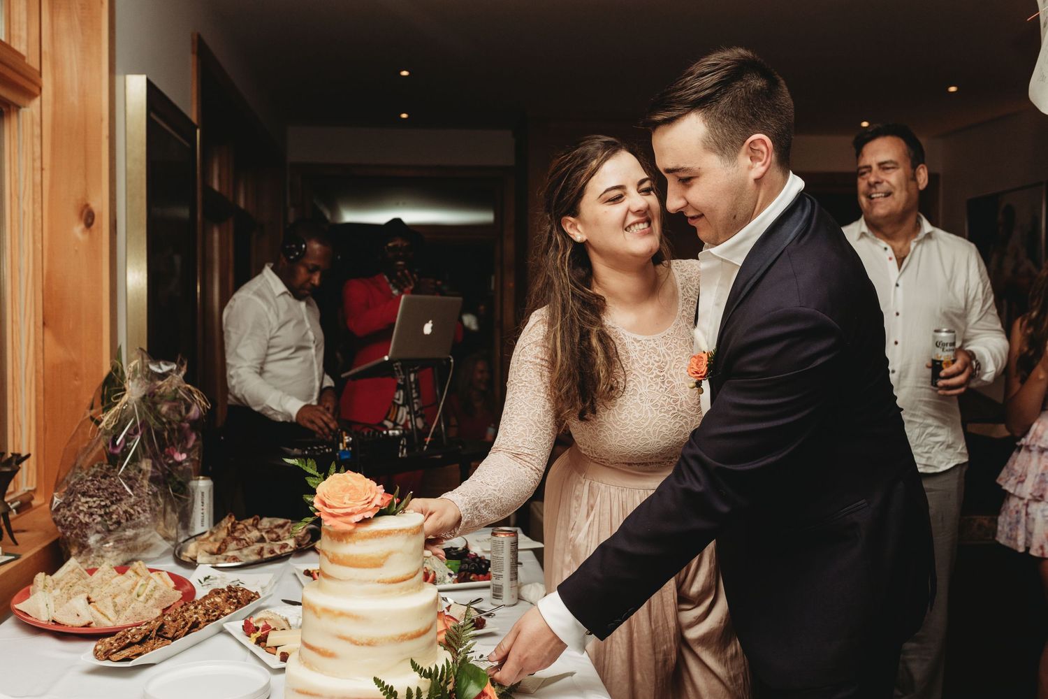 Couple sharing a moment while cutting their wedding cake at the dessert table.
