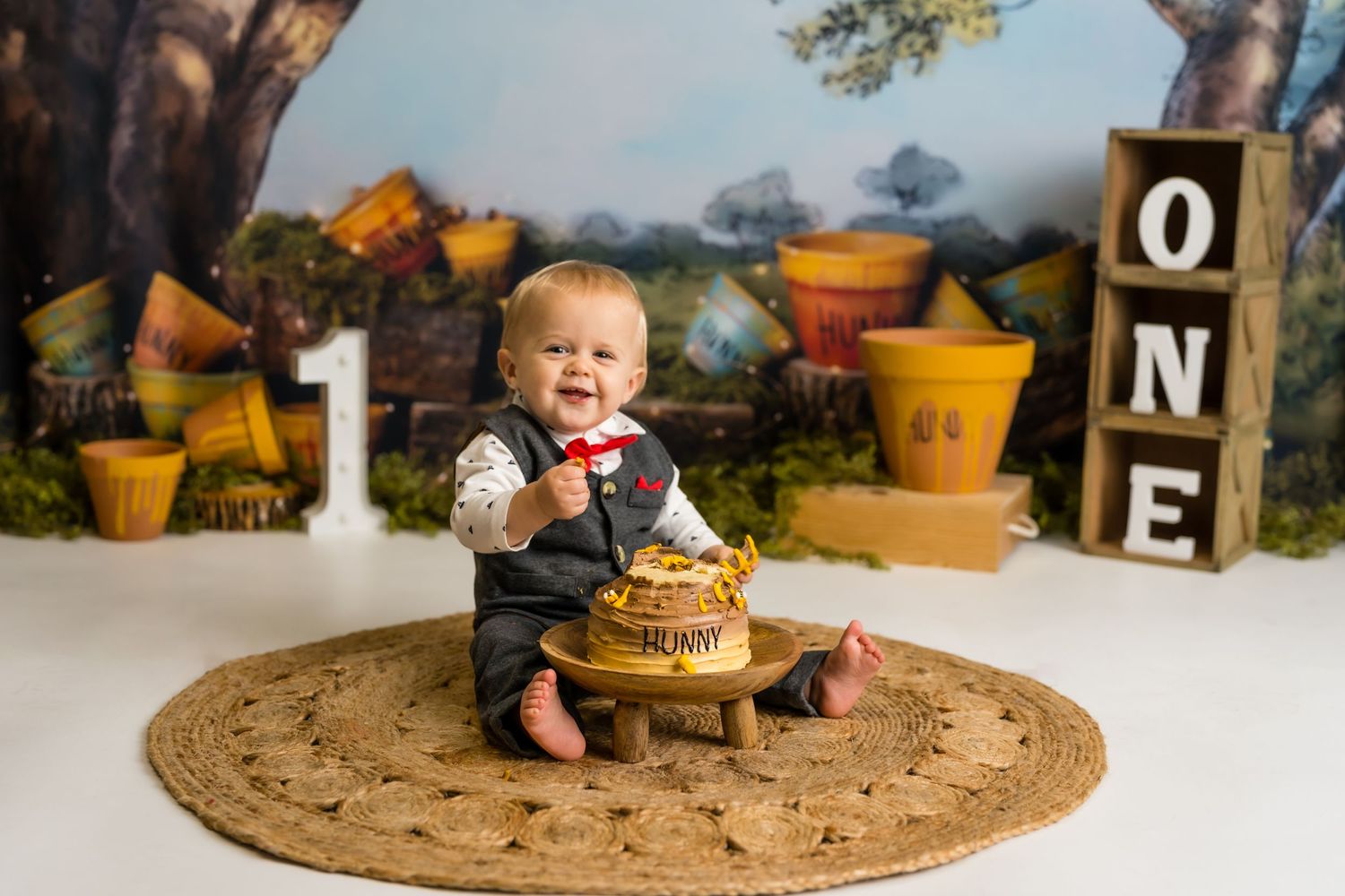 Winnie the Pooh 1st birthday cake smash session in a Bothell studio. Fun, authentic birthday photography by Filling the Frame Photography