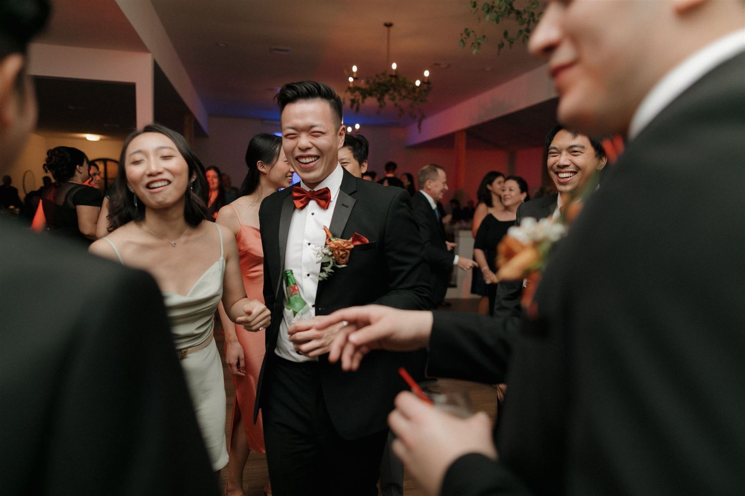 Wedding reception celebration with guests gathered in modern venue.