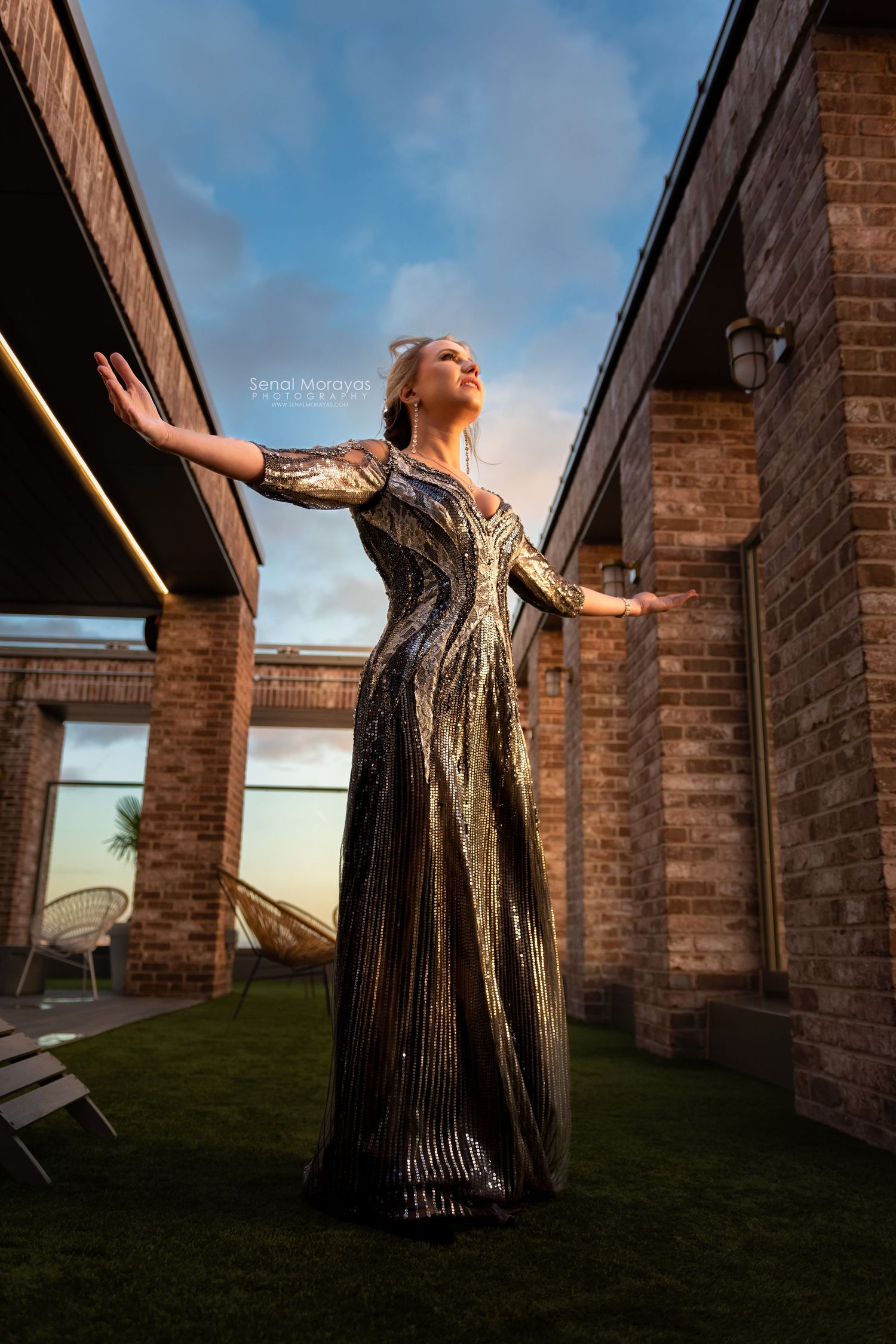 Artistic outdoor photoshoot featuring a sparkly dress against brick architecture.