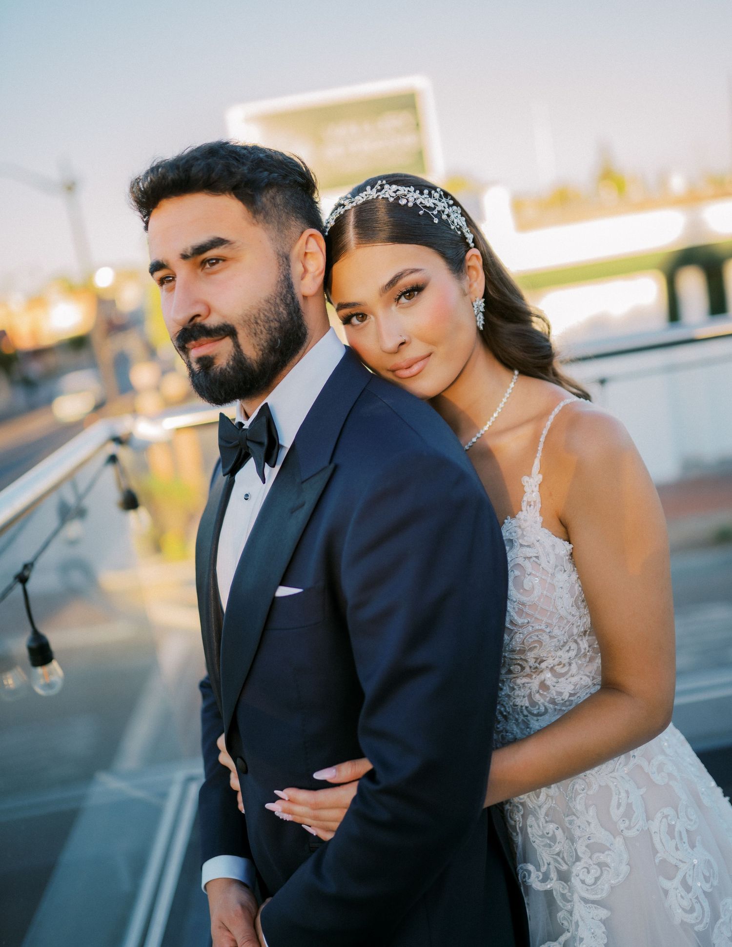 A romantic sunset portrait of newlyweds embracing on a rooftop venue.