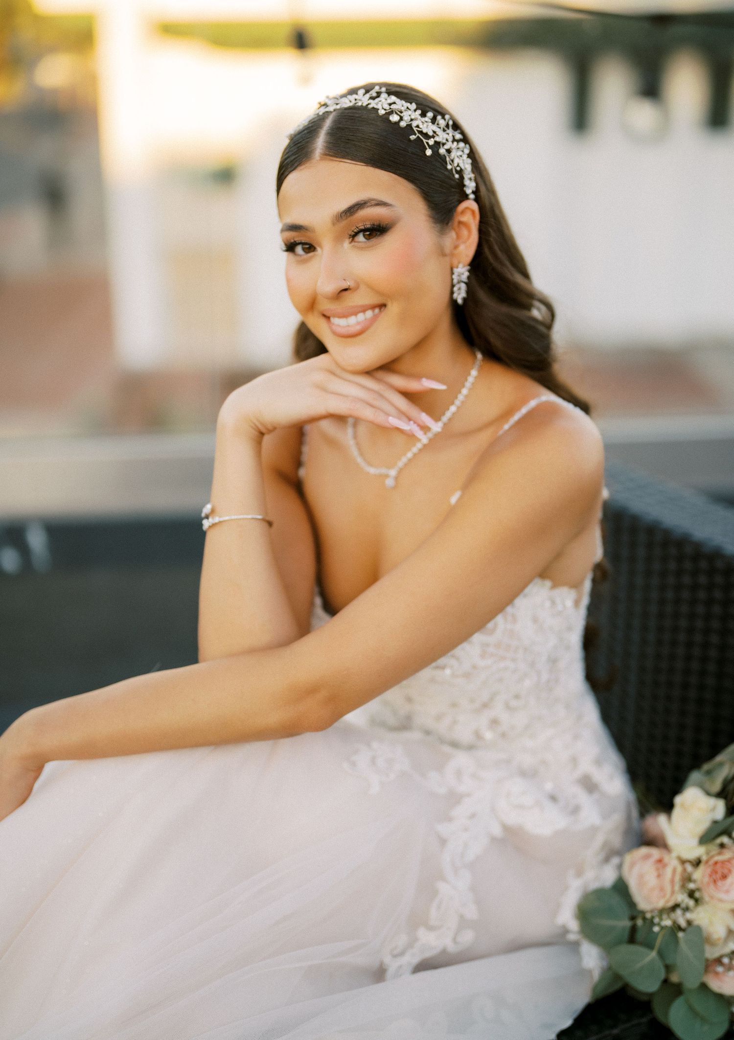 A bridal portrait showcasing an elegant lace gown and sparkling accessories at sunset.