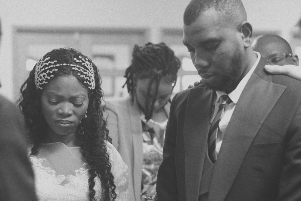 Black and white emotional wedding ceremony moment with elegant bridal accessories.