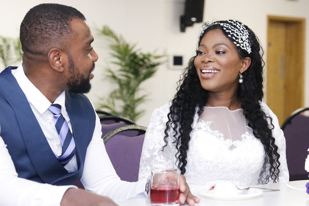 A couple in wedding attire share a joyful moment during their reception.